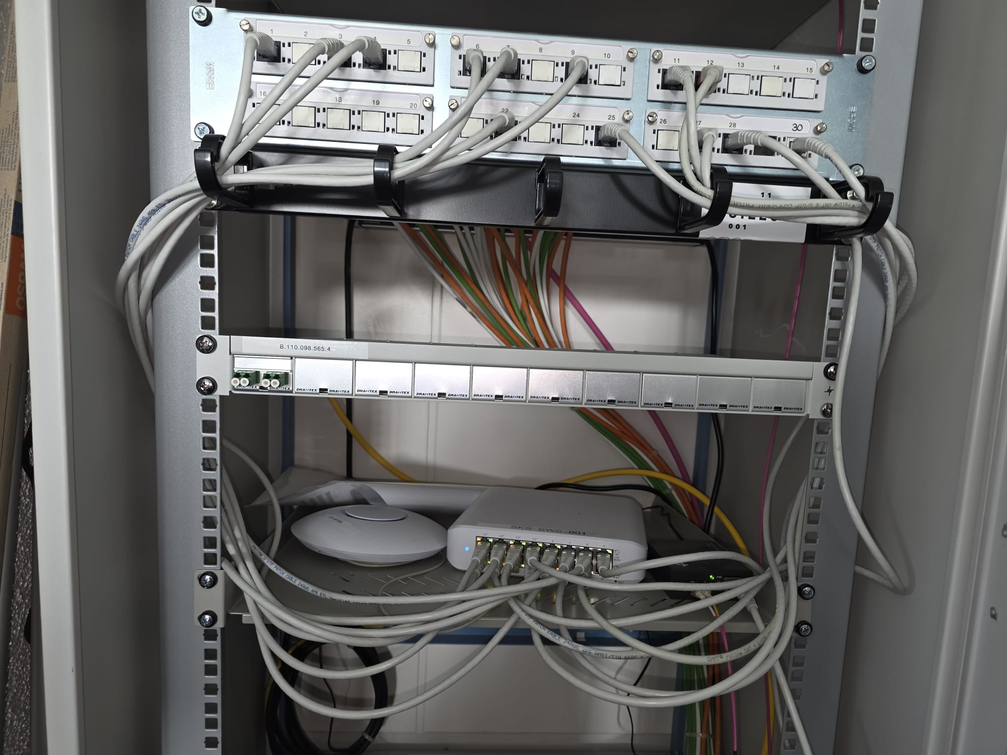 Saubere Installation eines Netzwerkschranks mit Patchpanel und Switch für eine stabile und effiziente Verbindung.